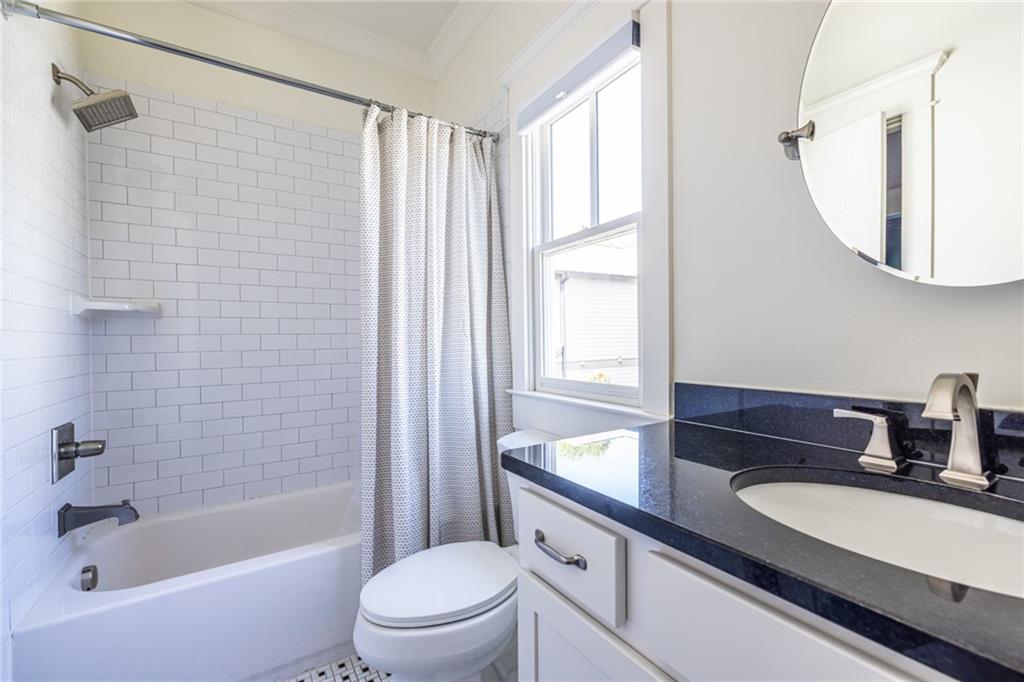 1005 Braeburn Lane Decatur, GA 30030 - Photo 21 of 25 a bathroom with a granite countertop sink a toilet a mirror a vanity and bathtub