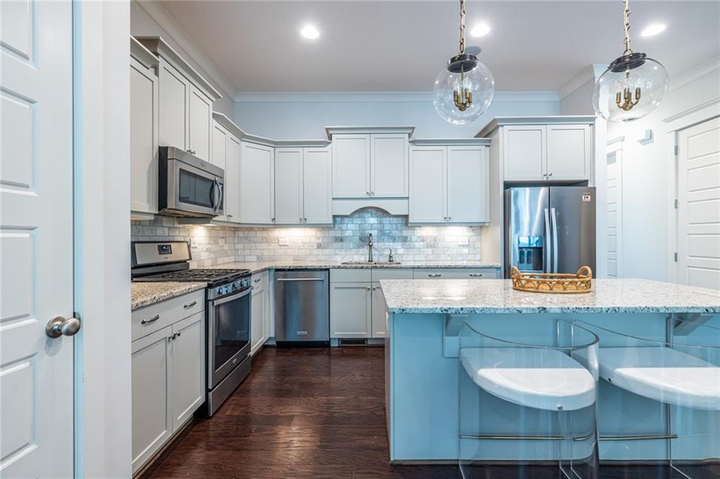 1005 Braeburn Lane Decatur, GA 30030 - Photo 6 of 25 a kitchen with stainless steel appliances granite countertop a kitchen island hardwood floor sink stove dining table and chairs