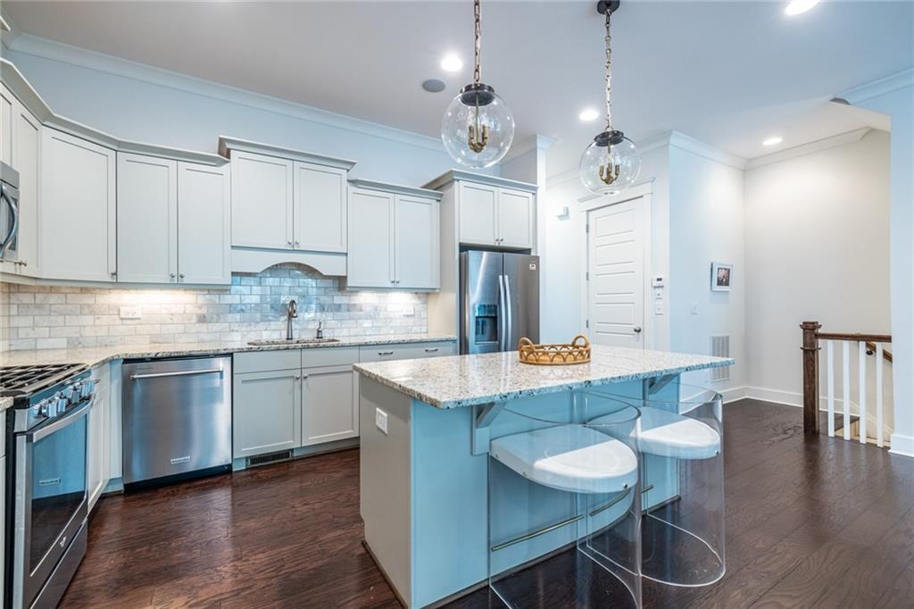 1005 Braeburn Lane Decatur, GA 30030 - Photo 7 of 25 a kitchen with granite countertop a table chairs stove a sink dishwasher and cabinets with wooden floor