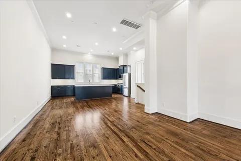a view of empty room with wooden floor and window
