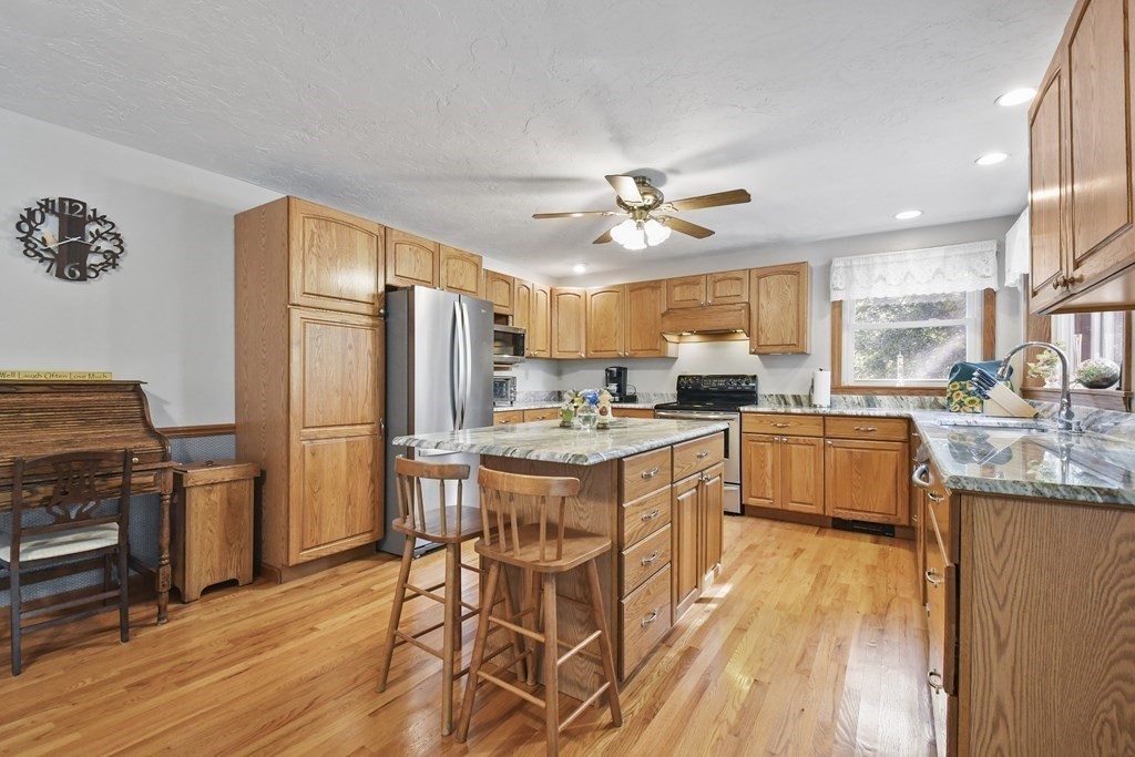 60 Lincoln Point Road Charlton, MA 01507 - Photo 14 of 42 a kitchen with stainless steel appliances kitchen island granite countertop a refrigerator a stove a sink dishwasher a dining table and chairs with wooden floor