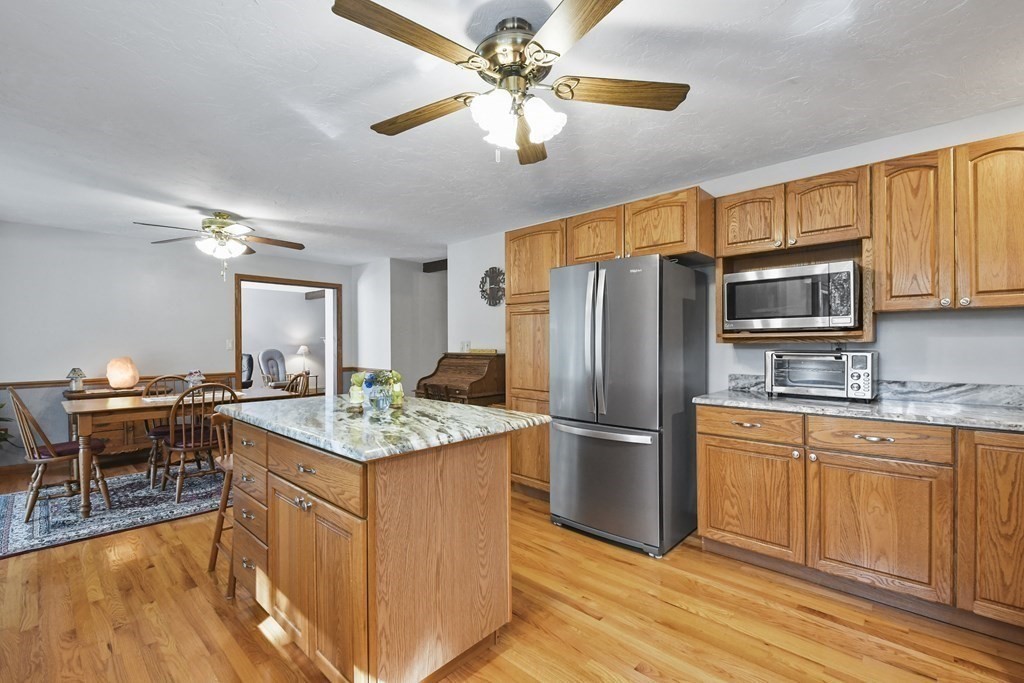 60 Lincoln Point Road Charlton, MA 01507 - Photo 16 of 42 a kitchen with stainless steel appliances granite countertop a refrigerator a stove top oven a sink dishwasher and white cabinets with wooden floor