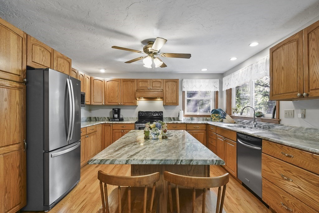 60 Lincoln Point Road Charlton, MA 01507 - Photo 18 of 42 a kitchen with stainless steel appliances granite countertop a kitchen island a stove a refrigerator a sink a dining table and chairs