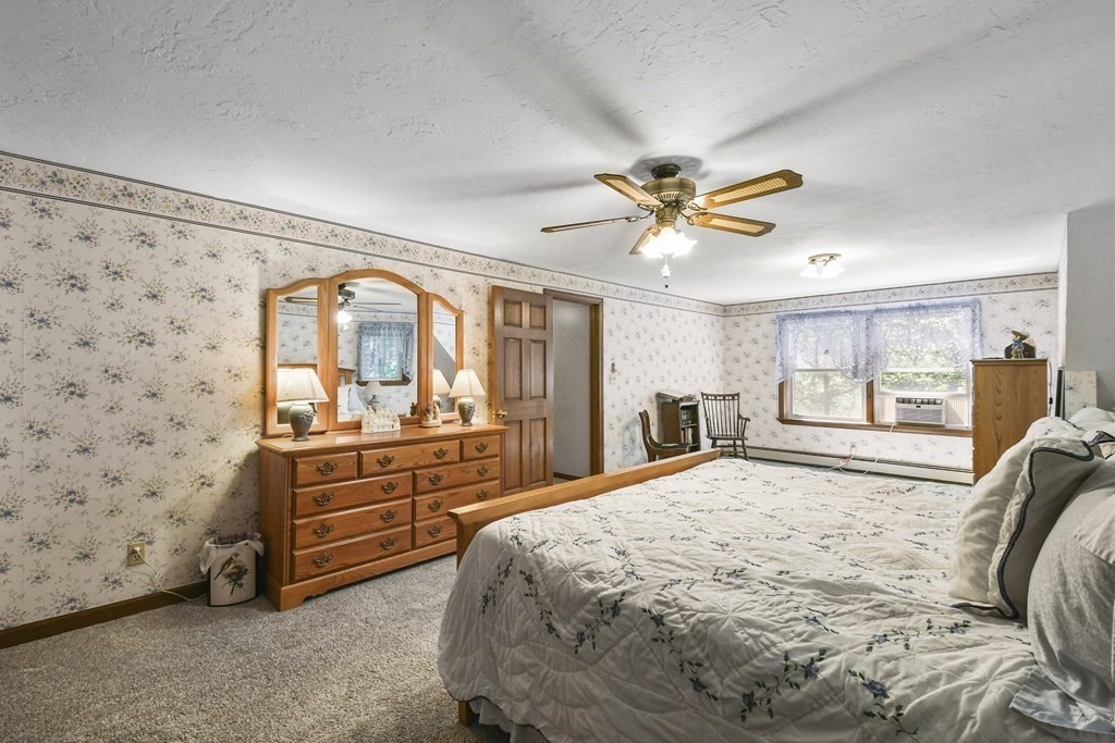 60 Lincoln Point Road Charlton, MA 01507 - Photo 26 of 42 a spacious bedroom with a large bed and a chandelier