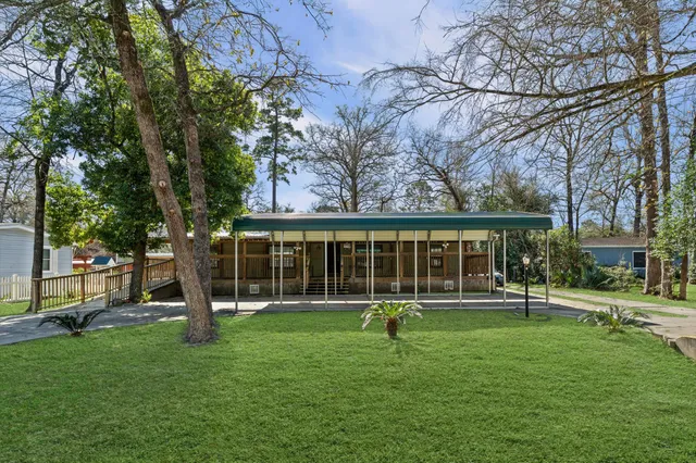 a front view of house with a garden and trees