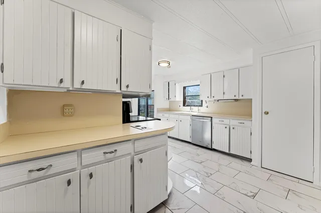 a view of a kitchen with white cabinets