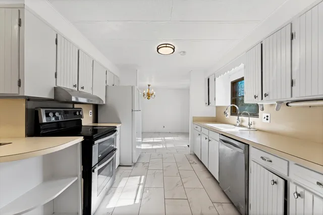 a kitchen with a sink stove and cabinets