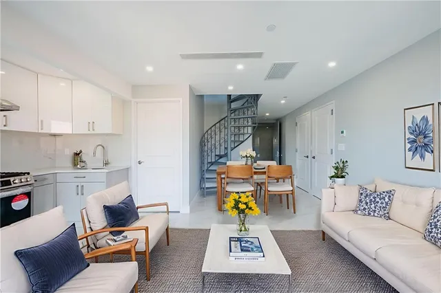 a living room with furniture and a kitchen view