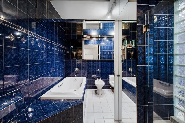 a spacious bedroom with a bed and a chandelier