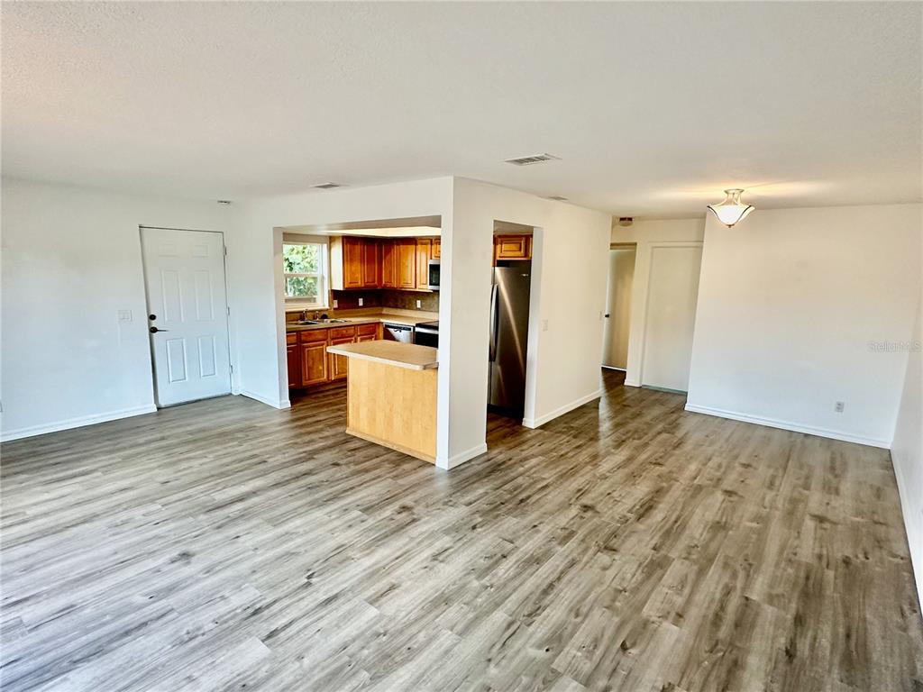 3303 West Shell Point Road, Unit B Ruskin, FL 33570 - Photo 3 of 22 a view of a kitchen with wooden floor and a ceiling fan