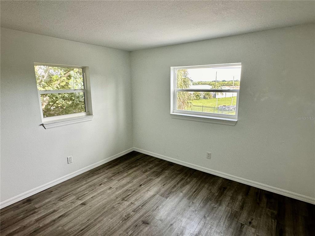 3303 West Shell Point Road, Unit B Ruskin, FL 33570 - Photo 6 of 22 a view of an empty room with wooden floor and a window