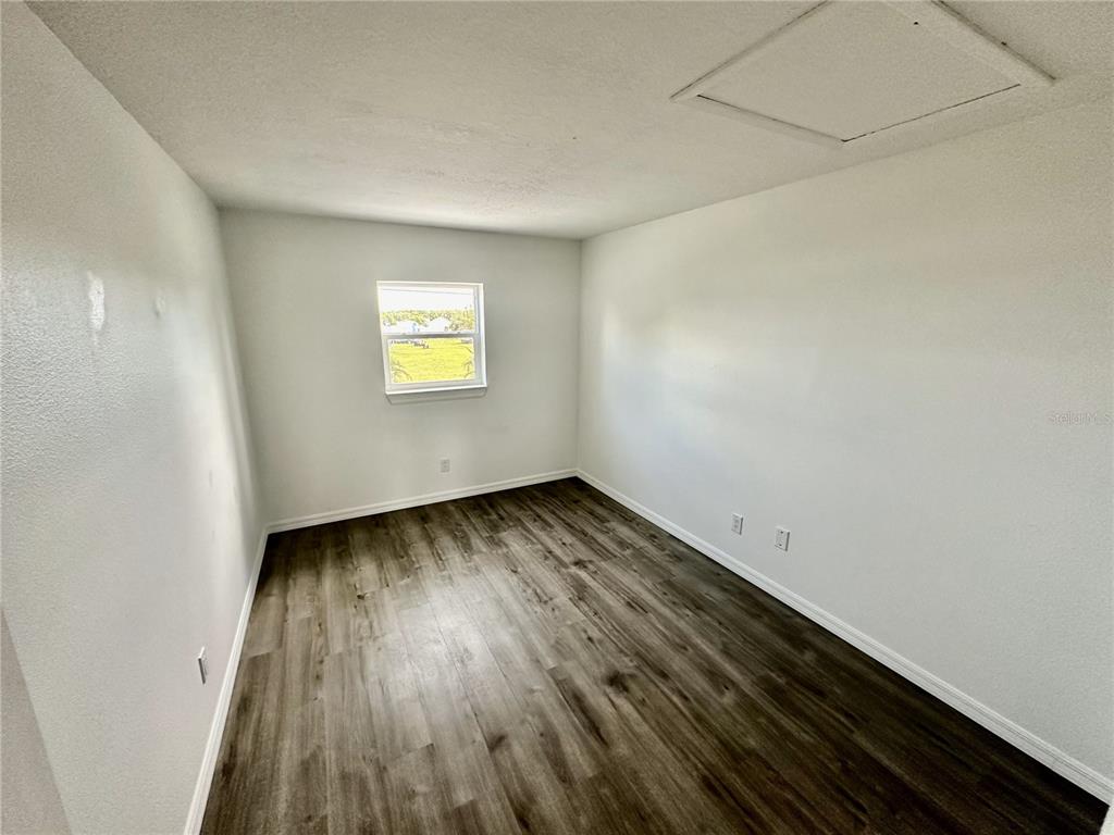 3303 West Shell Point Road, Unit B Ruskin, FL 33570 - Photo 8 of 22 a view of an empty room with wooden floor and a window
