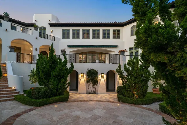 a front view of a house with garden and plants