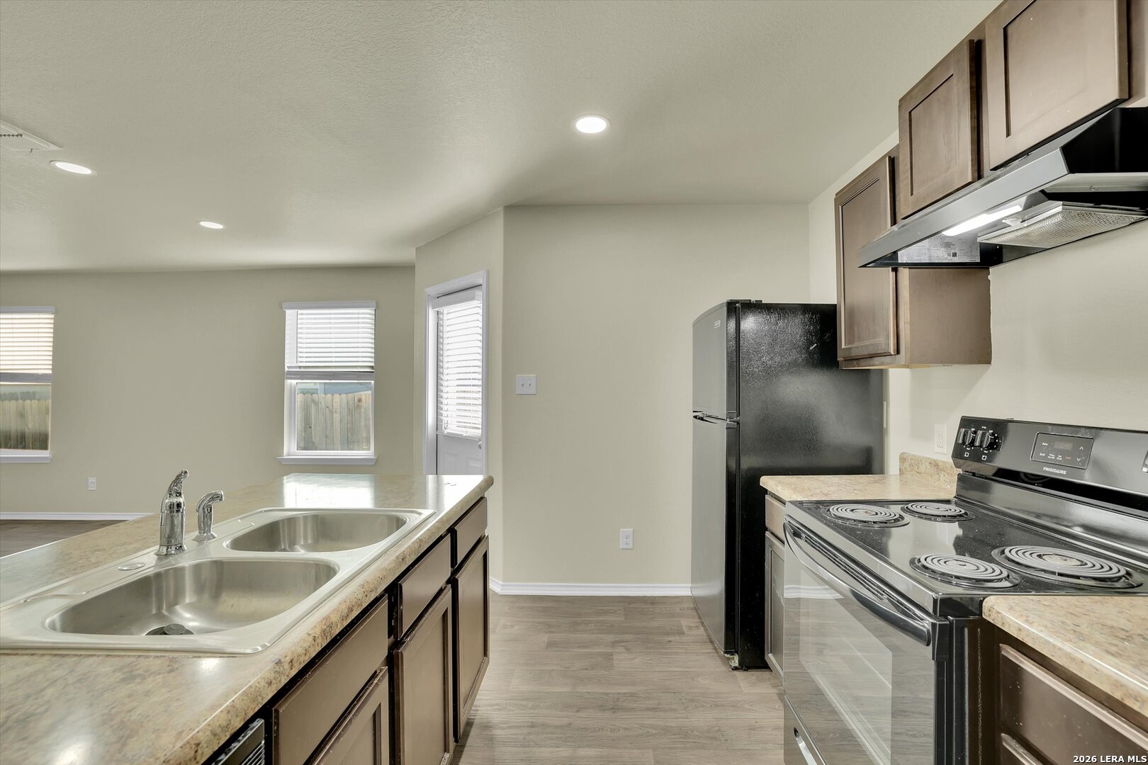 7639 Hercules Point San Antonio, TX 78252 - Photo 10 of 28 a kitchen with kitchen island granite countertop a sink stove and refrigerator