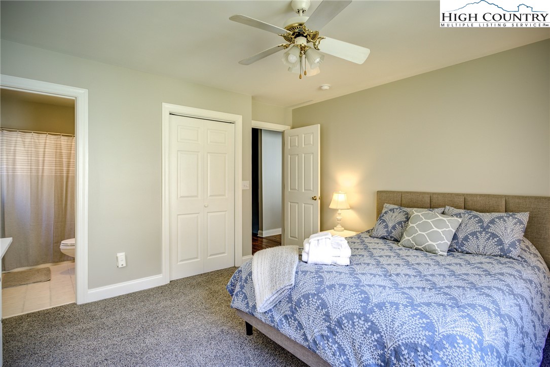 259 Ridge View Drive, Unit A Boone, NC 28607 - Photo 24 of 29 a bedroom with a large bed and a chandelier