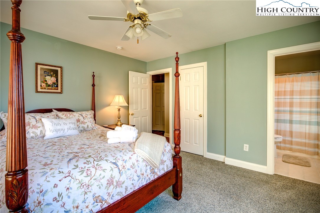 259 Ridge View Drive, Unit A Boone, NC 28607 - Photo 28 of 29 a bedroom with a large bed and a chandelier