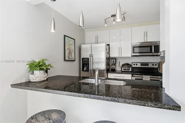 a kitchen with stainless steel appliances a sink stove and refrigerator