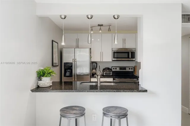 a kitchen with stainless steel appliances granite countertop a refrigerator and a stove top oven
