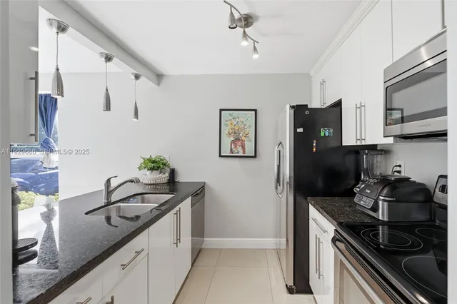 a kitchen with stainless steel appliances granite countertop a refrigerator a stove and a sink