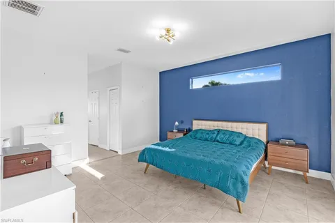 a bedroom with a bed and a potted plant