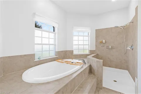 a bathroom with a tub a sink and a window