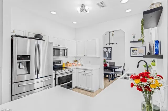 a kitchen with stainless steel appliances a refrigerator sink and cabinets