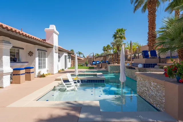 a view of a swimming pool with a patio and a garden