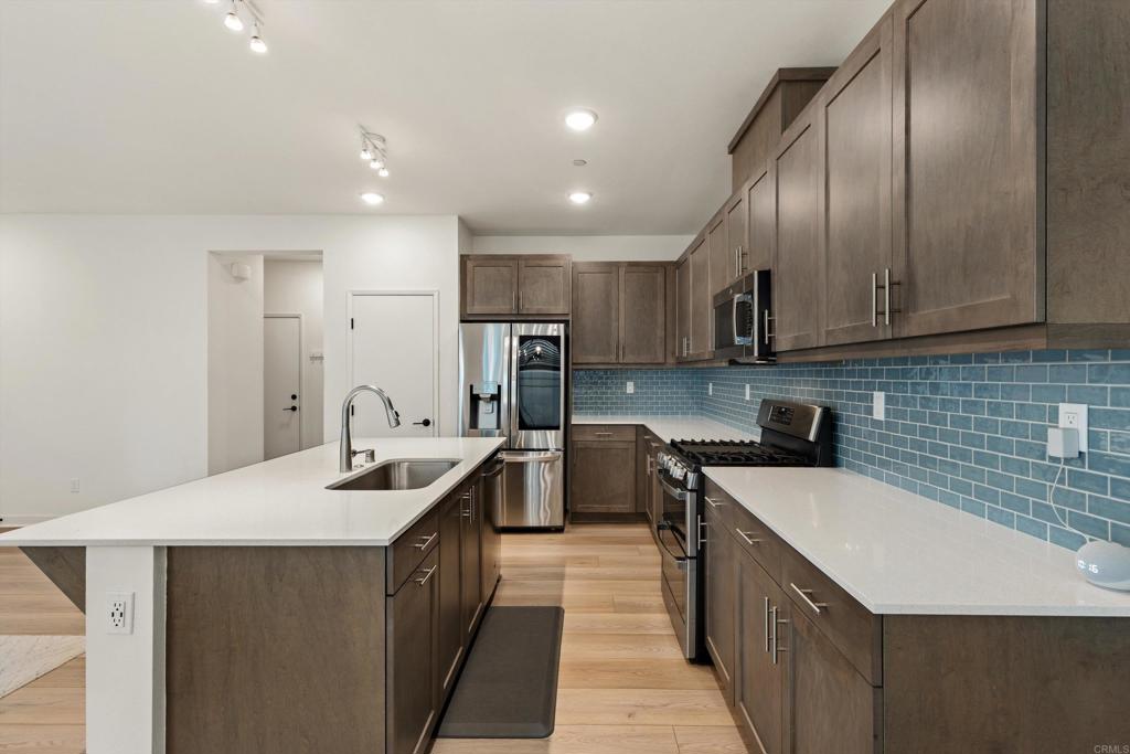 227 Canopy Trails Place Fallbrook, CA 92028 - Photo 11 of 66 a kitchen with stainless steel appliances granite countertop a sink a stove and a refrigerator