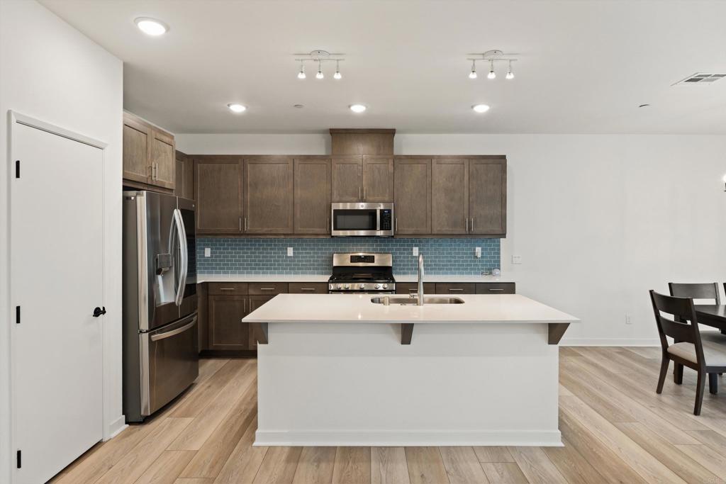 227 Canopy Trails Place Fallbrook, CA 92028 - Photo 13 of 66 a kitchen with kitchen island a sink appliances and wooden floor