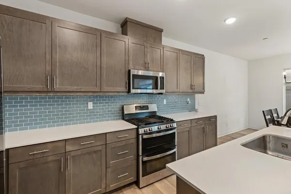a kitchen with sink a microwave and cabinets