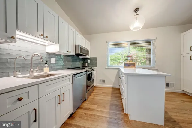 a kitchen with kitchen island granite countertop white cabinets and white appliances