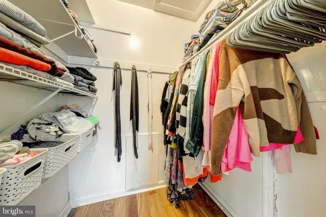 a view of walk in closet with clothes and shoes