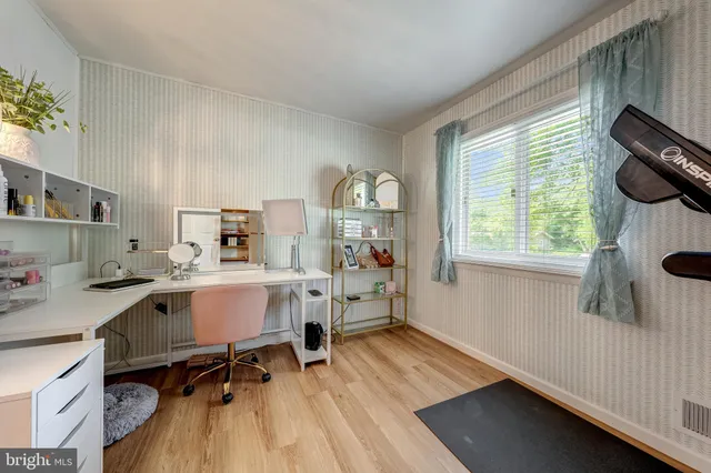 a view of a workspace with furniture and a window
