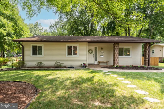 a view of a house with a yard and a large tree
