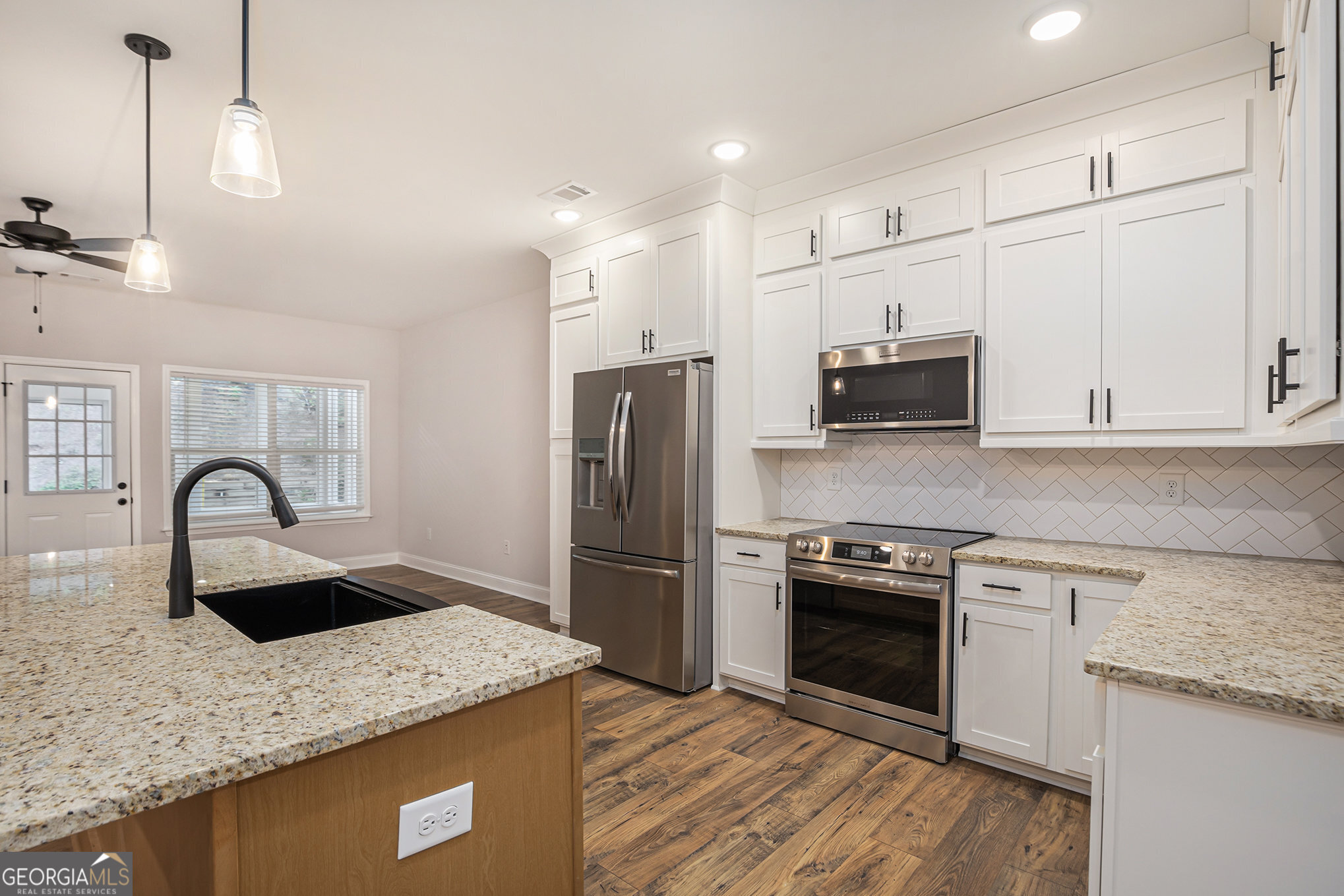 138 Crest Pointe Bremen, GA 30110 - Photo 8 of 22 a kitchen with stainless steel appliances granite countertop a sink a stove a refrigerator cabinets and wooden floor