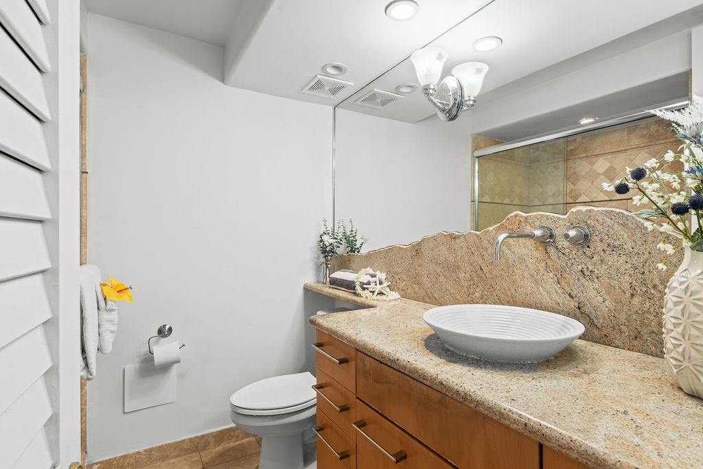 3785 Lower Honoapiilani Road, Unit 208 Lahaina, HI 96761 - Photo 34 of 50 a bathroom with a granite countertop sink a toilet and a mirror