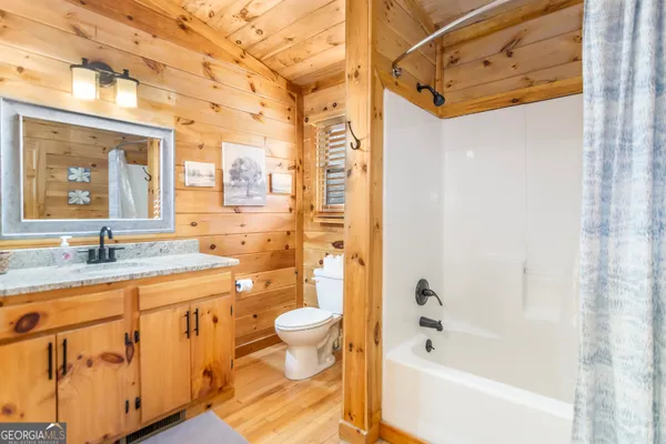 a bathroom with a granite countertop sink a toilet and shower
