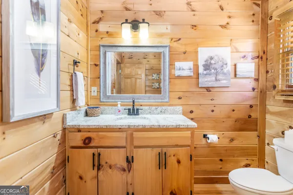 a bathroom with a granite countertop sink mirror vanity and toilet