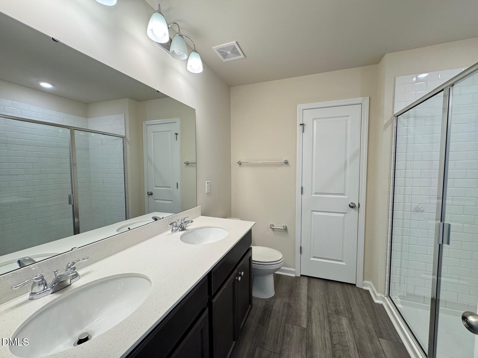 3440 Pinnacle Peak Drive Raleigh, NC 27604 - Photo 19 of 31 a bathroom with a double vanity sink a toilet and a mirror