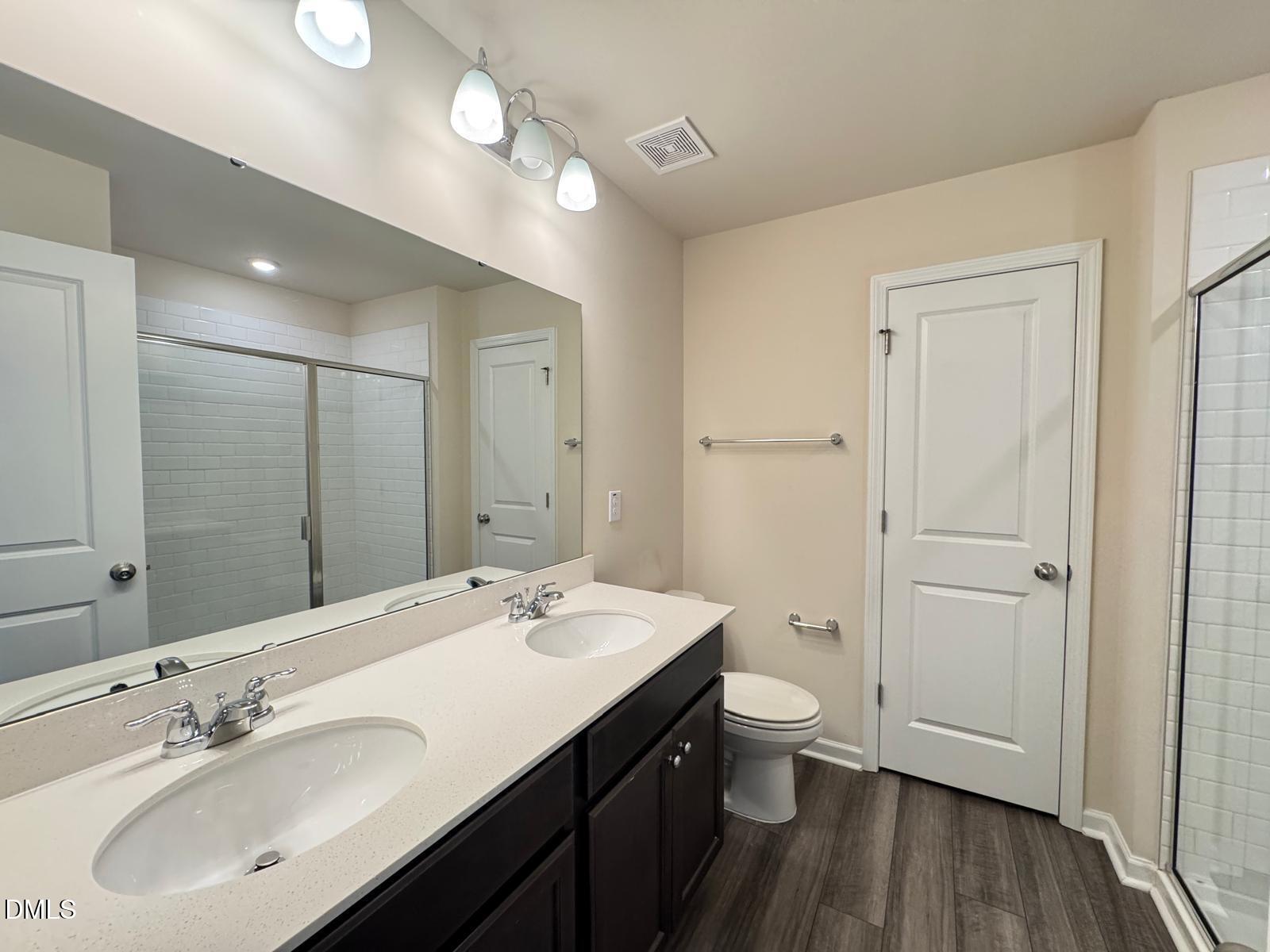 3440 Pinnacle Peak Drive Raleigh, NC 27604 - Photo 21 of 31 a bathroom with a double vanity sink toilet and a mirror