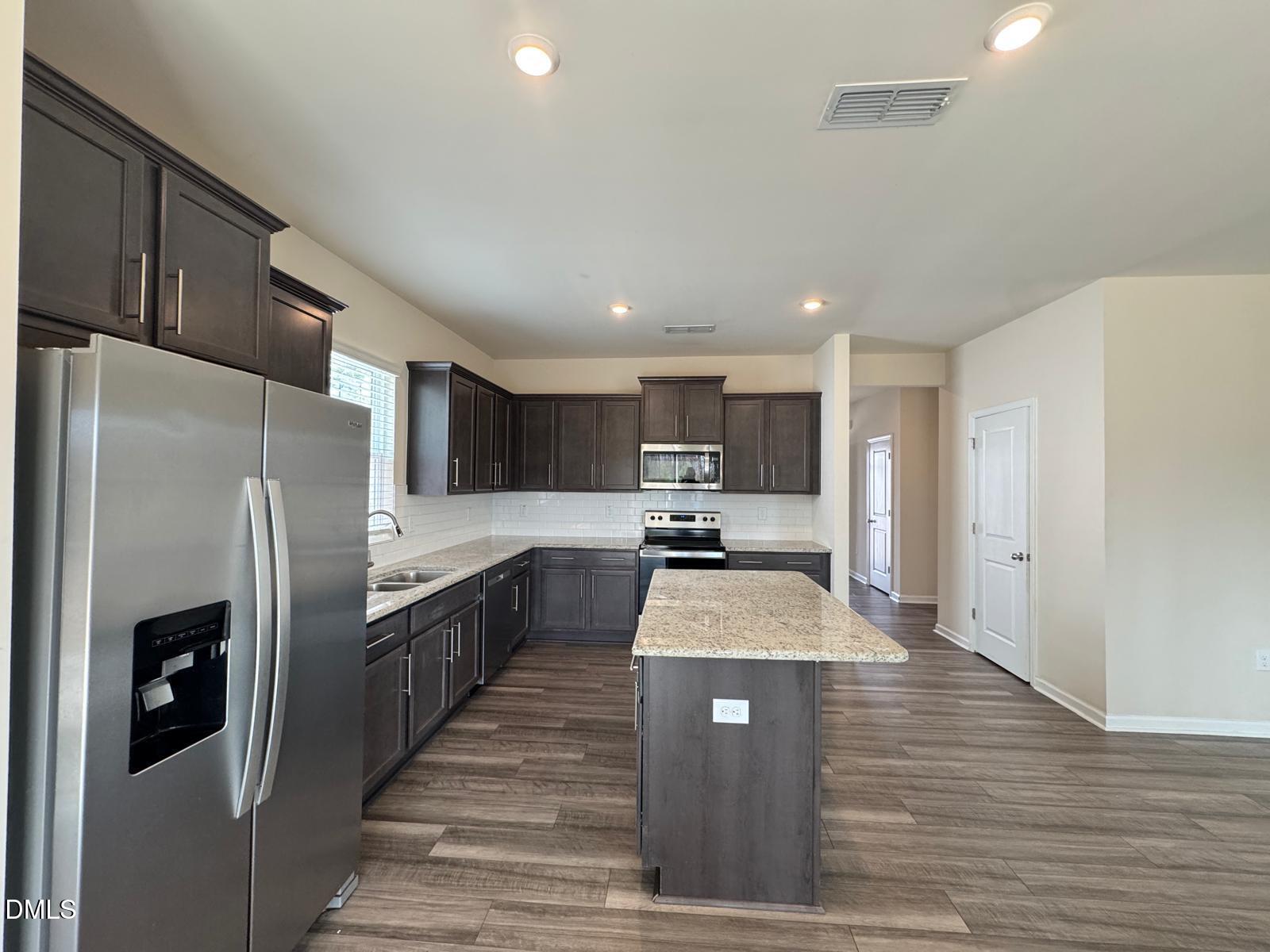 3440 Pinnacle Peak Drive Raleigh, NC 27604 - Photo 10 of 31 a large kitchen with stainless steel appliances kitchen island a stove a refrigerator a sink dishwasher and a refrigerator with wooden floor