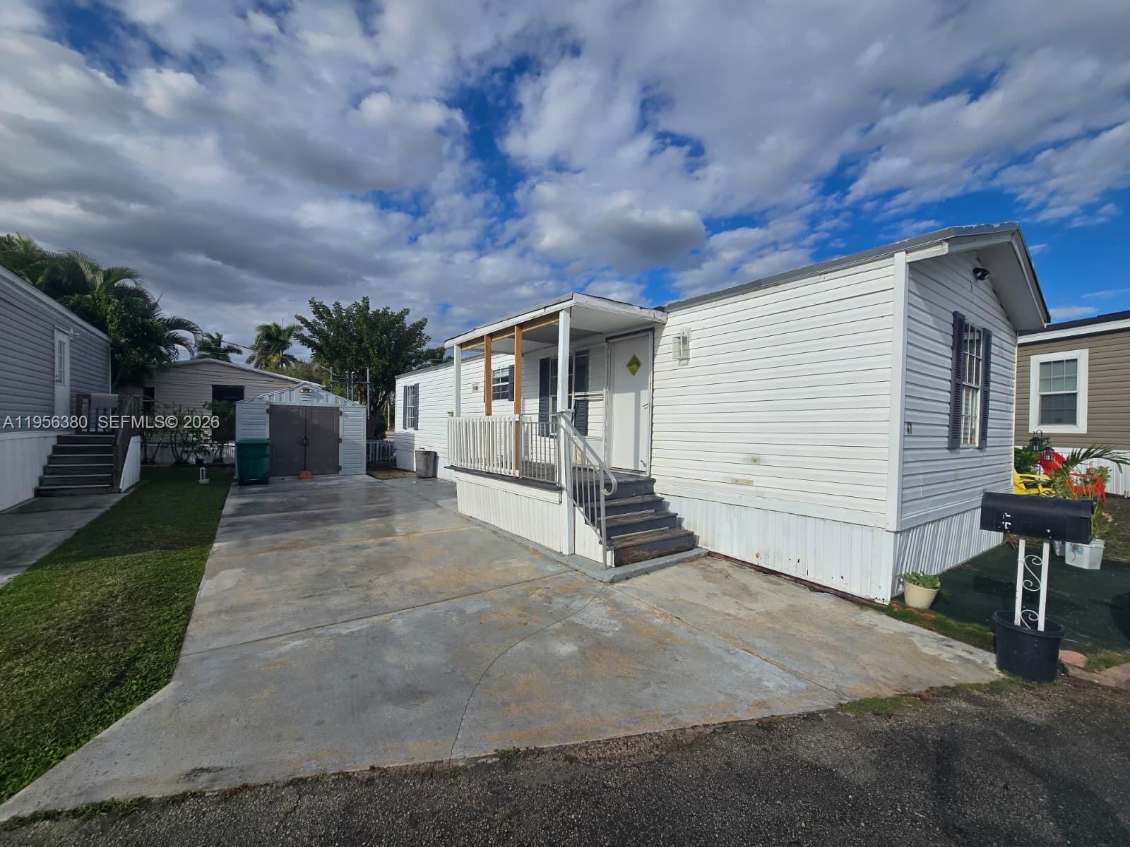 17350 Southwest 232nd Street, Unit 41 Miami, FL 33170 - Photo 2 of 15 a view of a white house with a yard and table and chairs