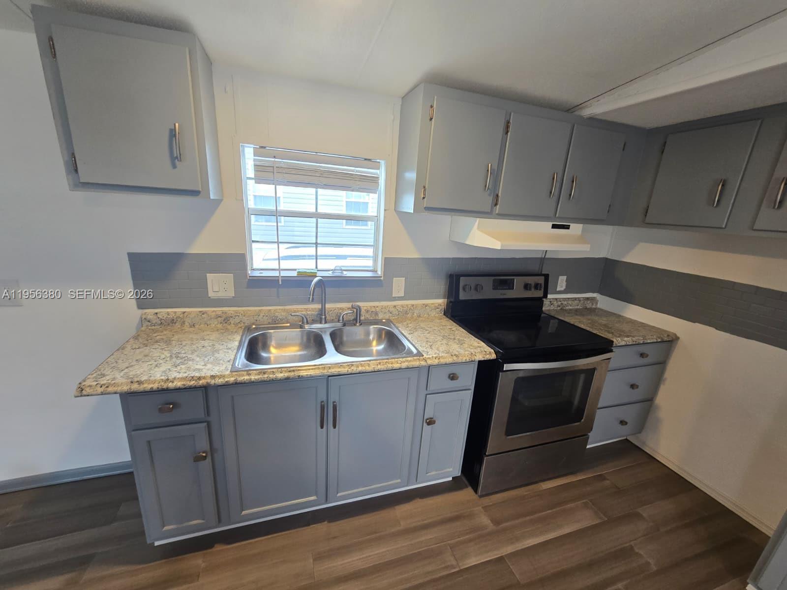17350 Southwest 232nd Street, Unit 41 Miami, FL 33170 - Photo 4 of 15 a kitchen with a stove sink and cabinets
