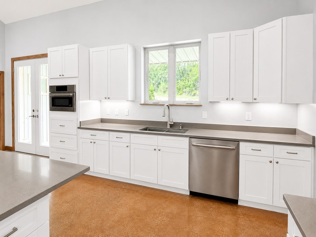 161 Balsly Road East Center Point, TX 78010 - Photo 11 of 28 a kitchen with granite countertop white cabinets white appliances and sink