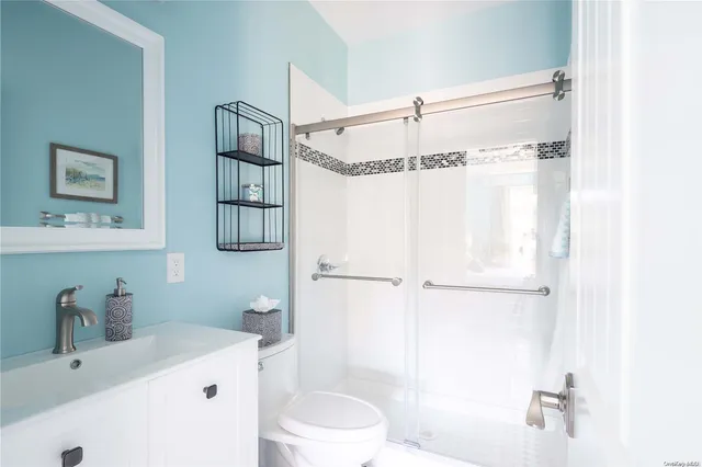 a bathroom with a sink a toilet and shower