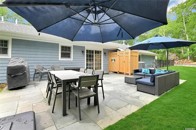 a patio with a table and chairs under an umbrella