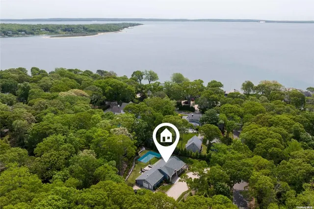 an aerial view of a house with a yard and lake view