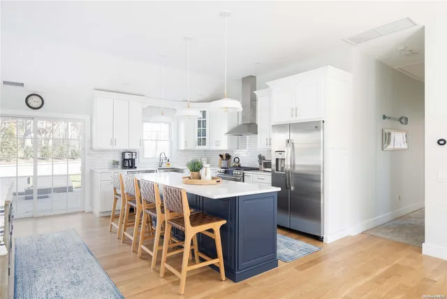 a kitchen with stainless steel appliances a dining table chairs and granite counter tops