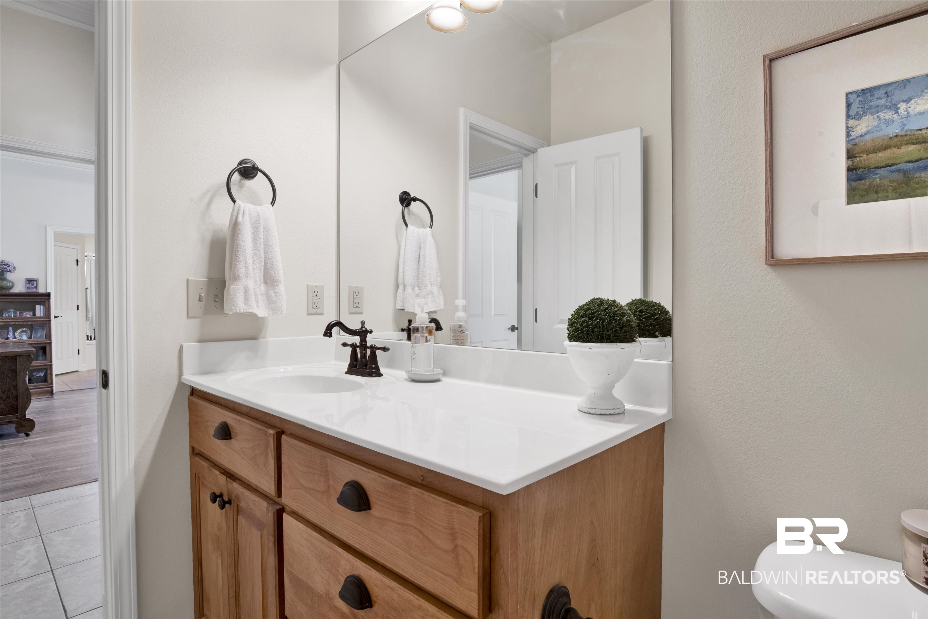 10368 Gayfer Rd Extension Fairhope, AL 36532 - Photo 28 of 43 Vanity featuring a light wood-finish base, integrated sink, and white countertop