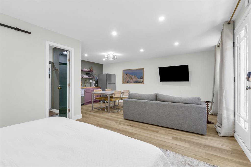 4121 Junius Street, Unit B Dallas, TX 75246 - Photo 13 of 32 Open-concept living area featuring wood-finish flooring, recessed lighting, and a white paneled entry door